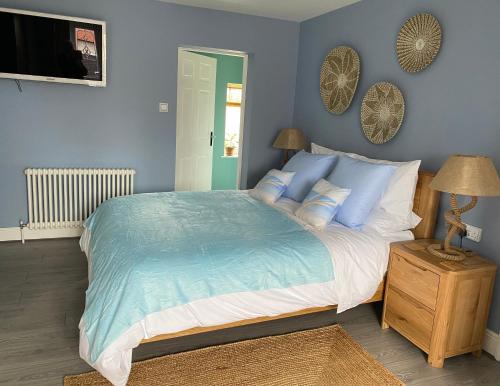 um quarto com uma cama grande e paredes azuis em Sea Breeze Apartment Skegness em Skegness