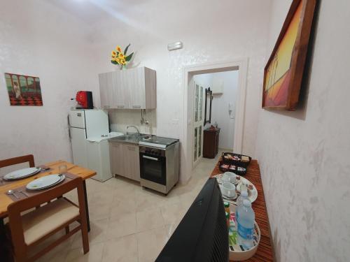 a small kitchen with a table and a dining room at Regina Elena Apartments in Taranto