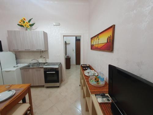 a kitchen with a television and a table in a room at Regina Elena Apartments in Taranto