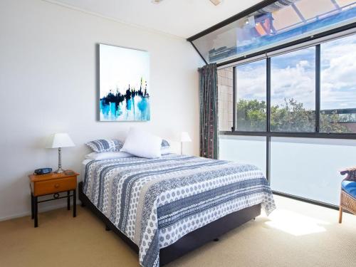 a bedroom with a bed and a large window at Beach View At One Mile 8 infinity complex pool and WI FI in Anna Bay