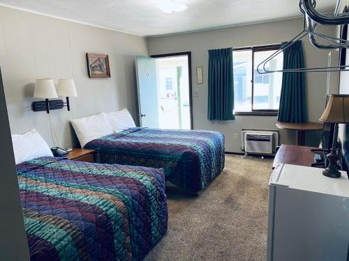 ein Hotelzimmer mit zwei Betten und einem Fenster in der Unterkunft Wigwam Motel in Cody