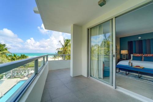 a bedroom with a view of the ocean from a balcony at The Sagamore Hotel South Beach in Miami Beach