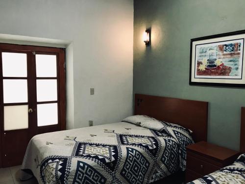 1 dormitorio con 1 cama con edredón en Hotel Casa Santo Domingo en Zacatecas
