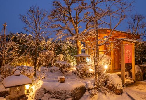 高山市にある旅館　一の松の夜雪に覆われた庭園