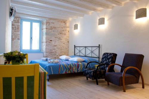 um quarto com uma cama e cadeiras num quarto em Studios Barbaro em Rovinj