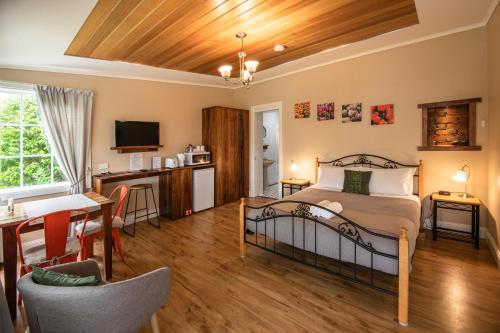 a bedroom with a bed and a kitchen and a table at Alexandria Bed and Breakfast in Wynyard