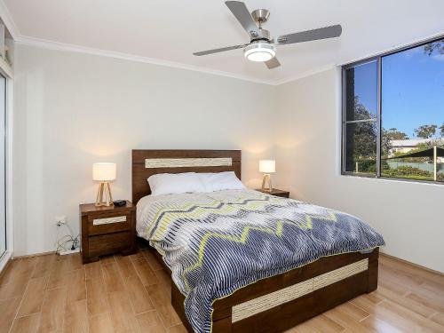 a bedroom with a bed and a ceiling fan at The Point 10, 5-7 Mitchell St - stunning water views in Soldiers Point