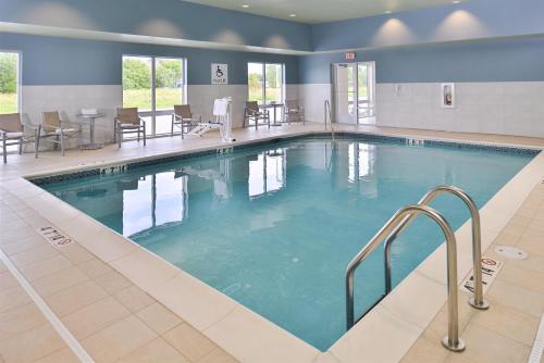 uma grande piscina num hotel com mesas e cadeiras em Holiday Inn Express & Suites Omaha Airport, an IHG Hotel em Carter Lake