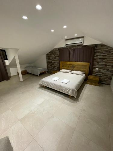 a bedroom with a bed and a brick wall at Villa white-design in Eilat