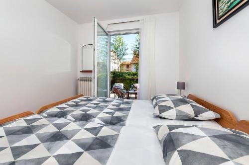 ein Schlafzimmer mit einem schwarz-weiß karierten Bett in der Unterkunft Apartments Marija - 500 m from beach in Rovinj