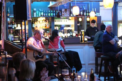 a man playing a guitar in a bar at Castle Hotel in Dublin