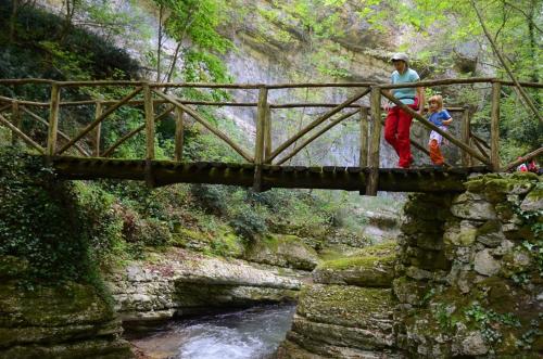 a group of people walking on a bridge over a river at Charming Apartment in Abbateggio with Mountain View, 60 m² in Abbateggio