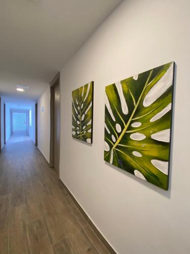 a hallway with three paintings on the wall at Hotel La Esperanza Ciudad Jardín in Cali