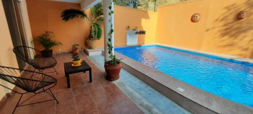 a swimming pool with two chairs and a table next to it at La Vivienda Villa in Santa Cruz Huatulco