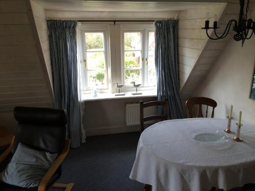 a dining room with a table and a window at Ferienhäuser im Sylter Gartenweg in Tinnum