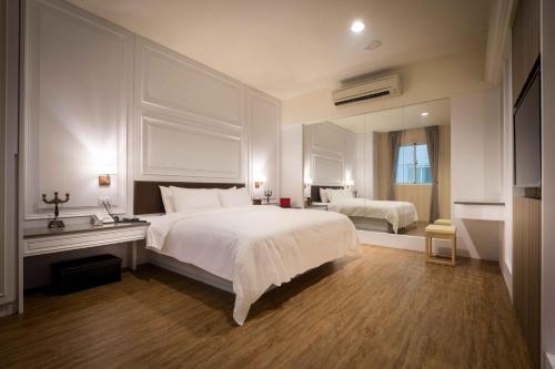 a bedroom with a large white bed and a window at Alegran Motel in Wuqi
