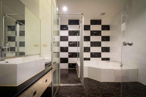 a bathroom with a tub and a sink and a shower at Alegran Motel in Wuqi