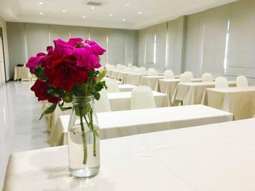 a vase filled with pink flowers sitting on a table at Oon Valley Farm Stay in Ban Mae Pha Haen