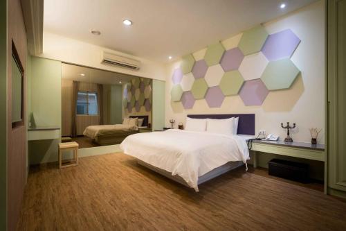 a bedroom with a large bed with a colorful wall at Alegran Motel in Wuqi
