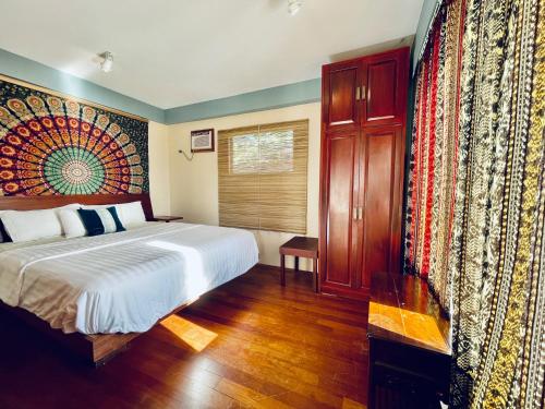 um quarto com uma cama grande e uma janela em Karuna Bohemian Owners Apartment em El Nido