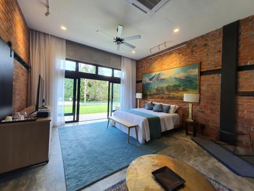 a bedroom with a bed and a brick wall at S`ekar Pinang Langkawi in Pantai Cenang