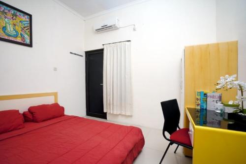 - une chambre avec un lit rouge et un bureau dans l'établissement DPARAGON PAMELA 4, à Yogyakarta