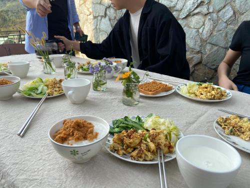 a table with plates of food and bowls of food at Evi Bnb in Fanlu