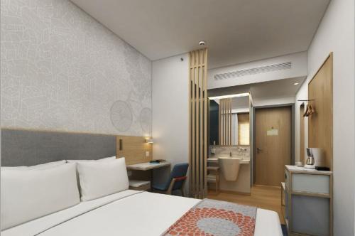 a bedroom with a bed and a desk and a bathroom at Holiday Inn Express Pune Pimpri by IHG in Pune