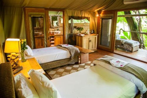 a bedroom with two beds and a bathroom at Summerfields Rose Retreat and Spa in Hazyview