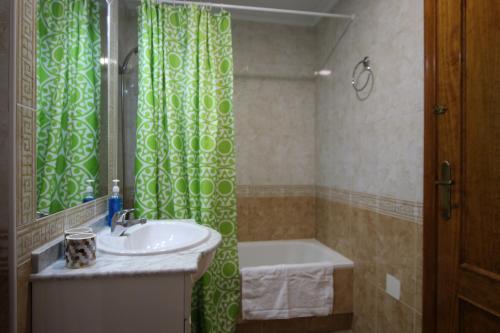 a bathroom with a green shower curtain and a sink at Apartamento LAVANDA , Costamarina, Cabo Roig in Orihuela Costa