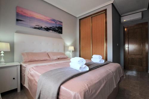 a bedroom with a bed with two towels on it at Apartamento LAVANDA , Costamarina, Cabo Roig in Orihuela Costa