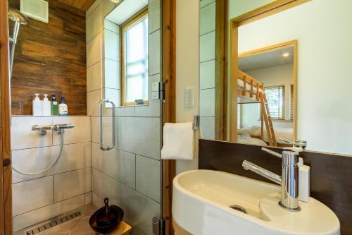 uma casa de banho com um lavatório e um chuveiro em Tsukinoki em Niseko