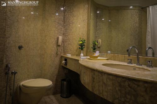 a bathroom with a sink and a toilet and a mirror at Mansingh Palace, Agra in Agra