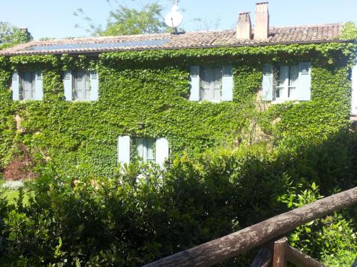 an ivy covered house with a wooden fence at Alloggio Al San Girolamo in Longiano