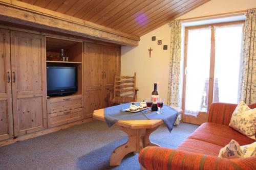a living room with a couch and a table and a tv at Ferienwohnung Neuhausen in Schönau am Königssee