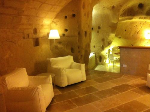 a living room with white chairs and a fireplace at Antico Convicino Rooms Suites & SPA in Matera