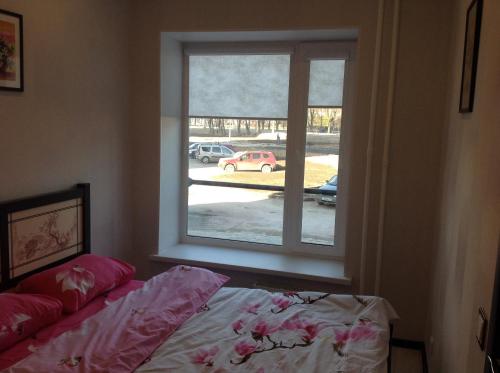 a bedroom with a window looking out at a parking lot at Phan Thiet Apartments однокомнатные апартаменты с отдельной спальней in Velikiy Novgorod