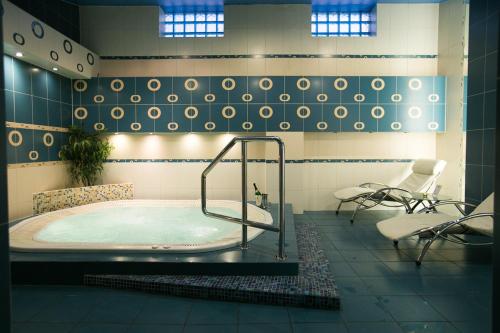 uma banheira de hidromassagem na casa de banho com duas cadeiras em Hotel&Spa Kameleon em Żory
