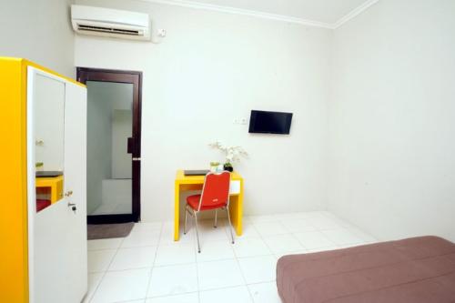 a room with a table and a red chair at DPARAGON DWIKORA in Palembang