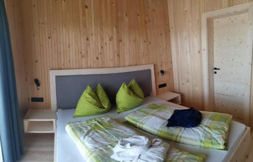 - une chambre avec un lit et des oreillers verts dans l'établissement Ritschhof, à Castelrotto