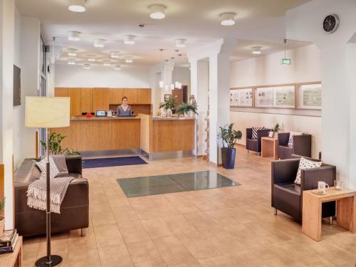 a lobby with couches and a man in the background at Ecoinn in Esslingen