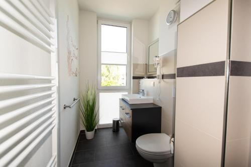 グロヴェにあるFerienwohnung Auszeitのバスルーム(トイレ、洗面台付)、窓が備わります。