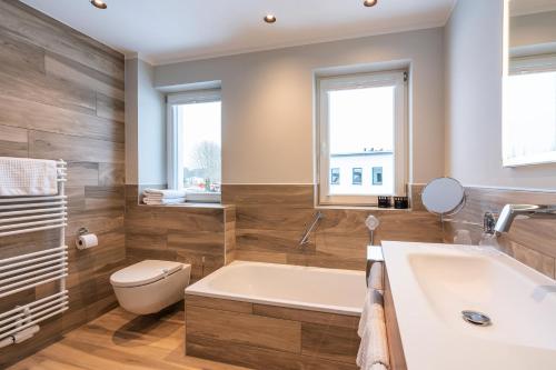 uma casa de banho com uma banheira, um WC e um lavatório. em TUI SUNEO Kinderresort Usedom em Trassenheide
