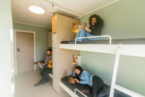 
a man and a woman sitting on a bunk bed at Bergen Hostel Montana in Bergen
