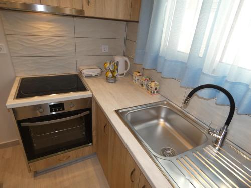 a small kitchen with a sink and a stove at "NISSI BEACH" Houses in Kos