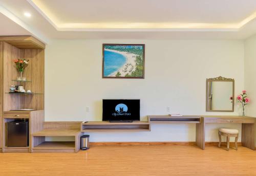 a room with a desk with a tv on a wall at Sky Beach D20 Nha Trang in Nha Trang