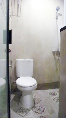 DJURAGANKAMAR GUNUNG ANYAR في سورابايا: حمام مع مرحاض أبيض ودش