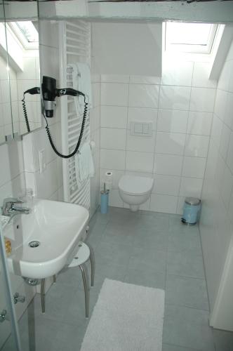 a white bathroom with a sink and a toilet at Hotel Württemberger Hof Garni in Rottenburg