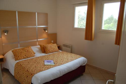 um quarto com uma cama com um livro em Résidence Côté Sud Peypin em Peypin
