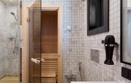 a bathroom with a shower and a glass door at Tenir Eco Hotel, Shymbulak Mountain Resort in Almaty